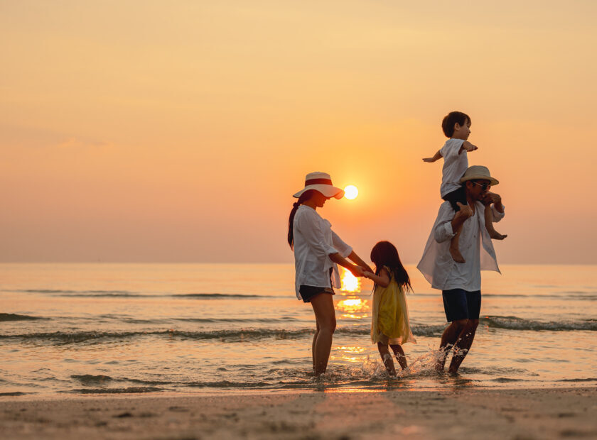 Happy asian family that enjoys beach activities during the summer holidays. parent and children enjoy the sunset sea on beach.Holiday travel concept, Summer vacations.